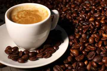 Cup of coffee with grains, closeup
