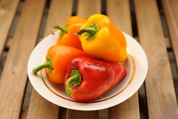 Fresh bright colored bell peppers in white plate
