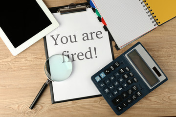 Message You're Fired on clapboard on wooden table, top view