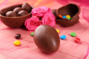 Chocolate Easter eggs with flowers on color tulle, closeup