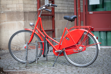 Fototapeta na wymiar Red bicycle parked in the city
