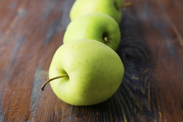Green apples on wooden background
