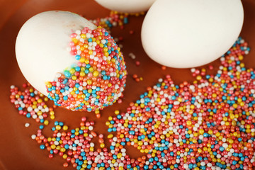 Decorating Easter eggs on color plate, closeup