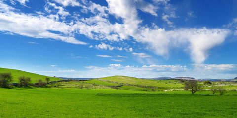 Colline verdi con nuvole nel cielo azzurro