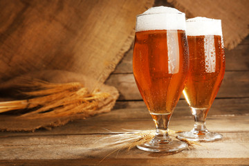 Glasses of beer on wooden background