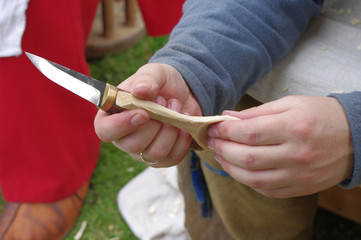 Woodcarver's hands working with knife in old style.