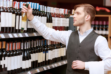 Sommelier in the store near shelves