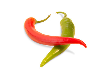 A whole red chili on top of a whole green chili isolated