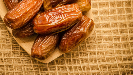 dried dates on wooden spoon cloth background