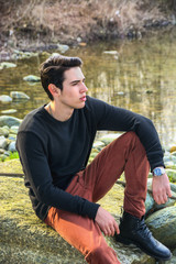 Naklejka na ściany i meble Attractive young man outdoor in nature, at river or water stream