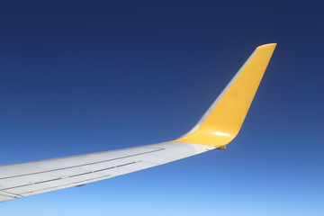 Wing of an airplane flying above sky