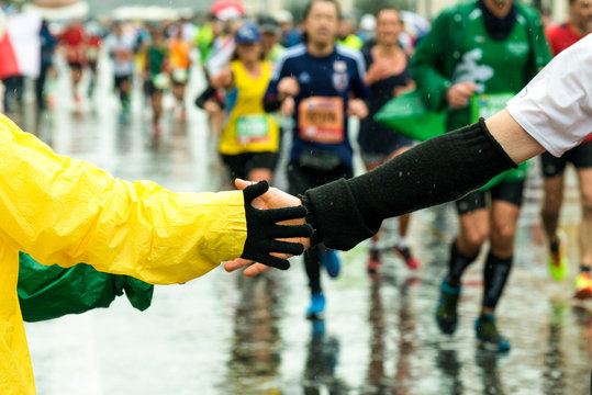 young give his hand to a runner during the marathon