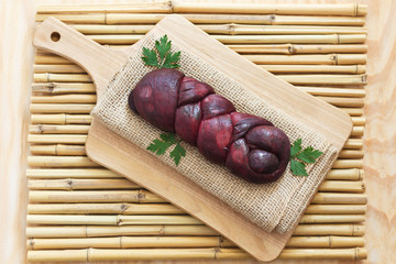 Braided Mozzarella marinated in red wine on wooden board