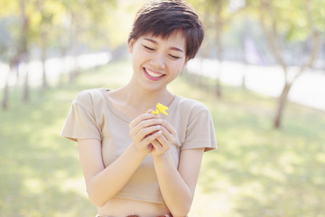 young and beautiful woman laughing to little flowers in hand wit