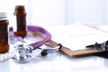 Doctor's stethoscope  with folder and bottle of pills on the