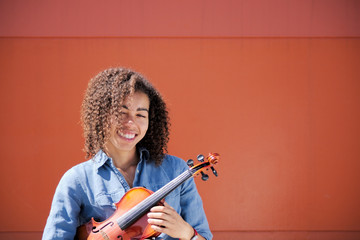 Young female holding violin under arm