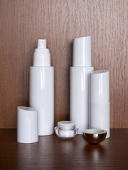 Several white bottles with cosmetic on a wooden table