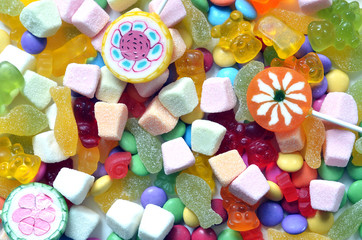 Fototapeta na wymiar Candy, lollipop, colored smarties and gummy bears background
