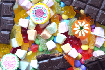 Candy, lollipop, chocolate, colored smarties and gummy bears 