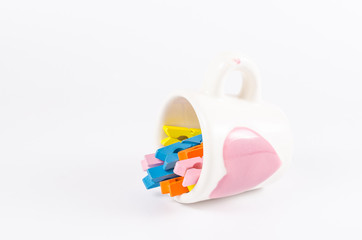 Group colorful pastel of wooden clothespins in coffee cup  isola