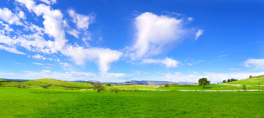 Panorama con verdi colline e un cielo azzurro con nuvole