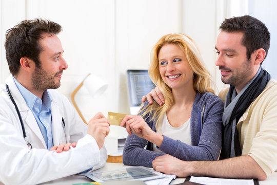 Young attractive couple paying consultation to the doctor