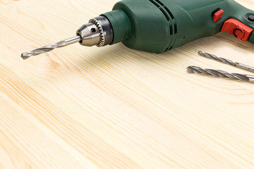 Electric drill on wooden floor background