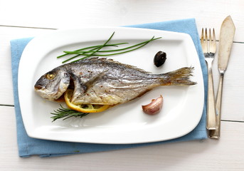 Garnished grilled whole sea bream with olives