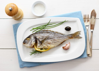 Garnished grilled whole sea bream with lemon