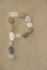 Fototapeta na wymiar Buchstabe P aus Kieselsteinen im Sand
