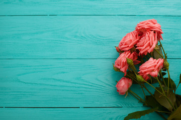 Fototapeta na wymiar Pink roses on blue wooden background