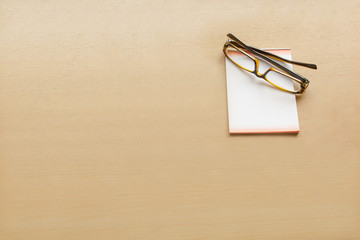 eye glasses and paper note on wooden table