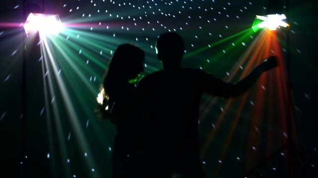 pair dancers dancing in spotlight at the club, silhouette
