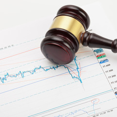 Wooden judge's gavel over stock market chart - close up shot