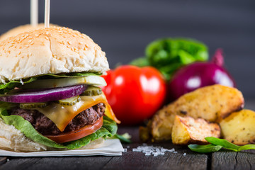 Homemade burger with vegetables on wooden table