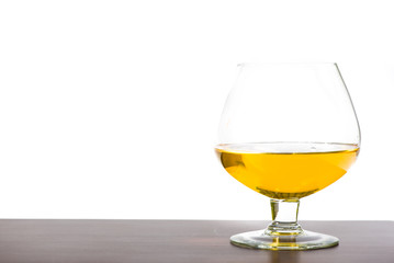  glass with rum or cognac isolated on wooden bar