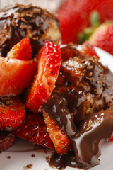 Profiteroles with strawberries and chocolate sauce