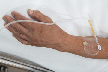 Left hand of the patient on clean bed in the hospital