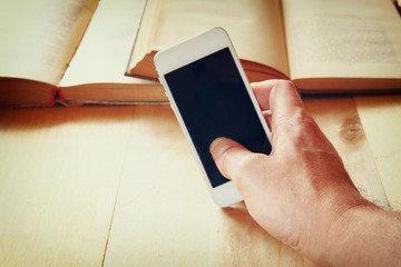 man holding smart phone over wooden table background