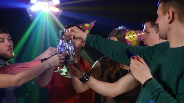 Nightclub : company of friends  party and dancing clink glasses