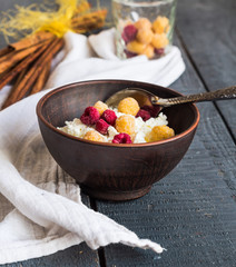 cottage cheese with raspberries in a dark clay plate, cinnamon s