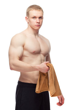 Happy muscular guy with towel over white background