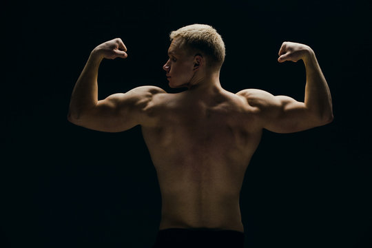 Close up of sports man's muscular isolated on black background