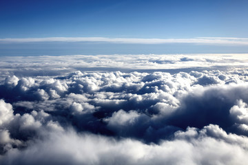 Obraz na płótnie Canvas Looking Down at White Fluffy Clouds Against a Blue Sky