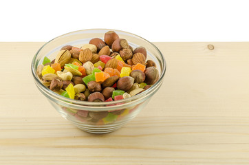 Different nuts and candied fruits in glass on the wooden table