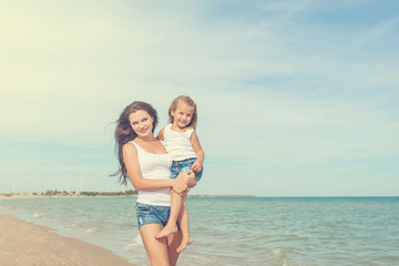 Mother and her daughter  having fun on the beach
