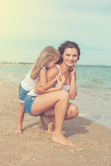 Fototapeta na wymiar Mother and her daughter having fun on the beach