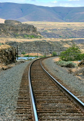 Fototapeta na wymiar Railroad tracks running along banks of the Columbia River.
