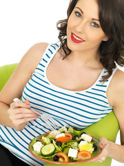 Young Woman Eating a Fresh Crispy Greek Salad