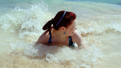 The girl is swimming in the sea waves